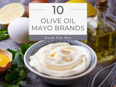 A bowl containing olive oil mayo, next to a bottle of olive oil, a lemon, and some eggs, looking at the best olive oil mayo brands