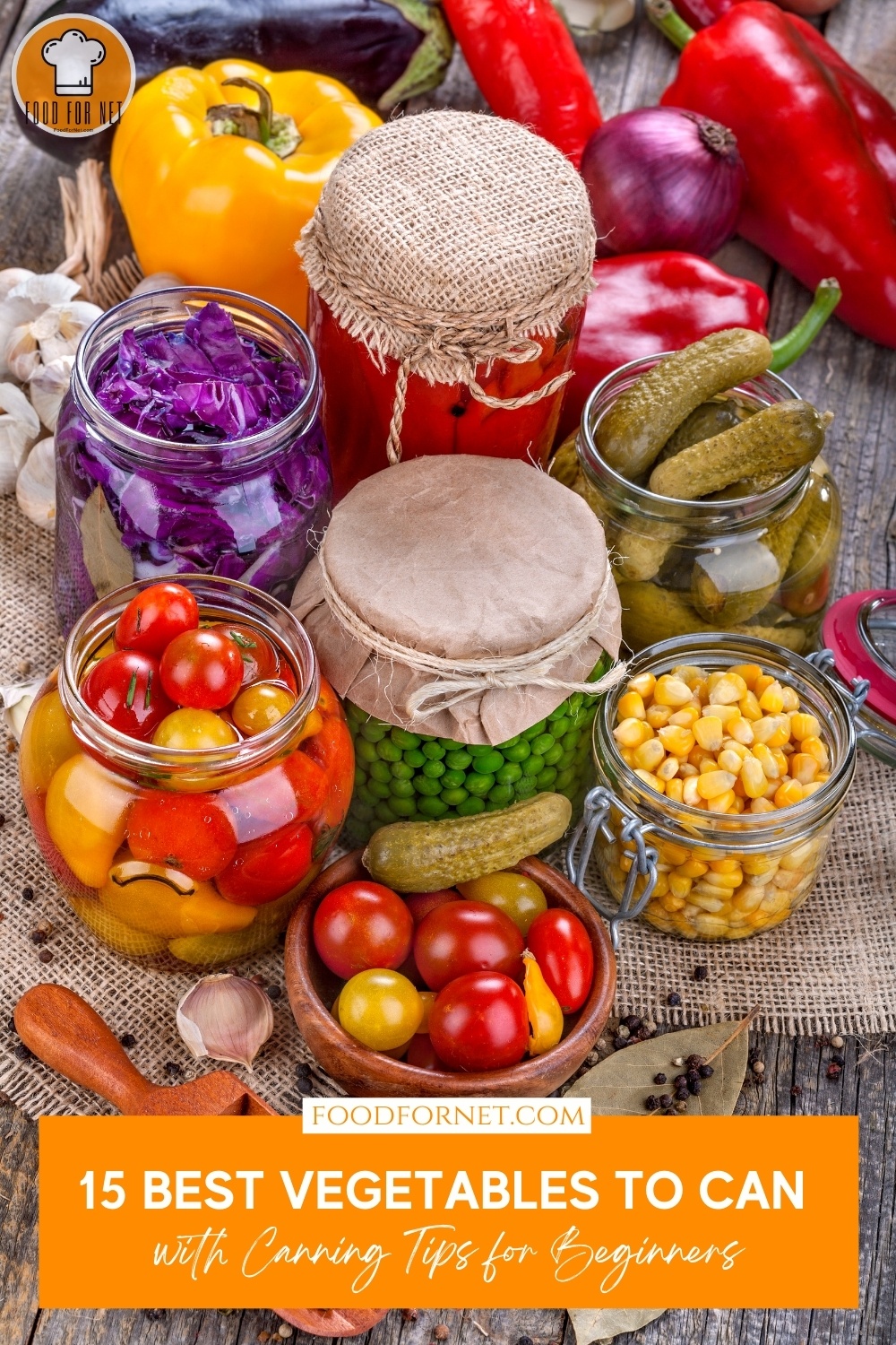 on a wooden surface is a spread of different jars of canned vegetables like tomatoes, green peas, cucumber, corn, and others, a wooden bowl of fresh tomatoes at the foreground, with loose spices and fresh veggies around it; with text overlay "15 Best Vegetables to Can with Canning Tips for Beginners"