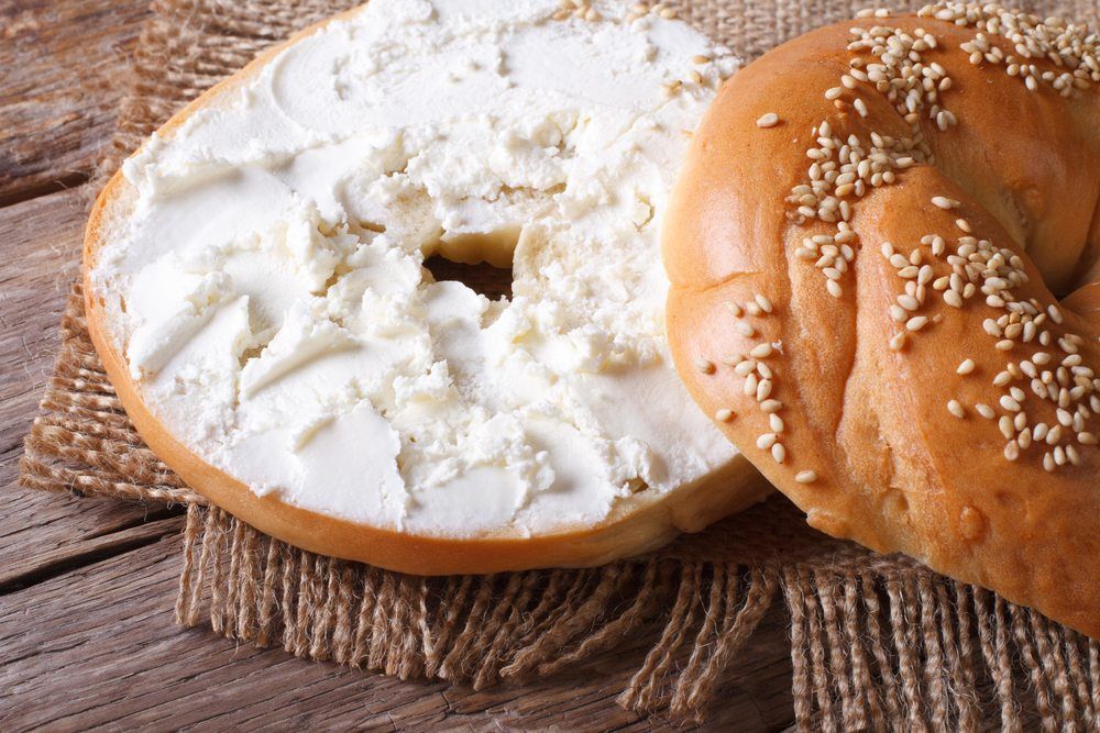 A bagel that has been sliced in half and spread with cream cheese