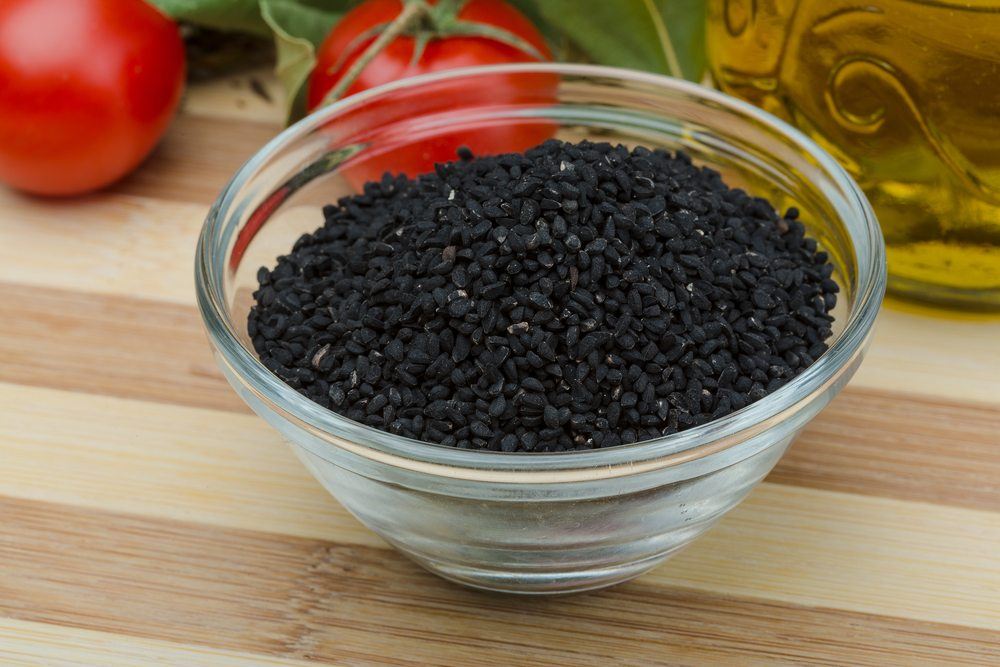 A small glass bowl containing nigella seeds