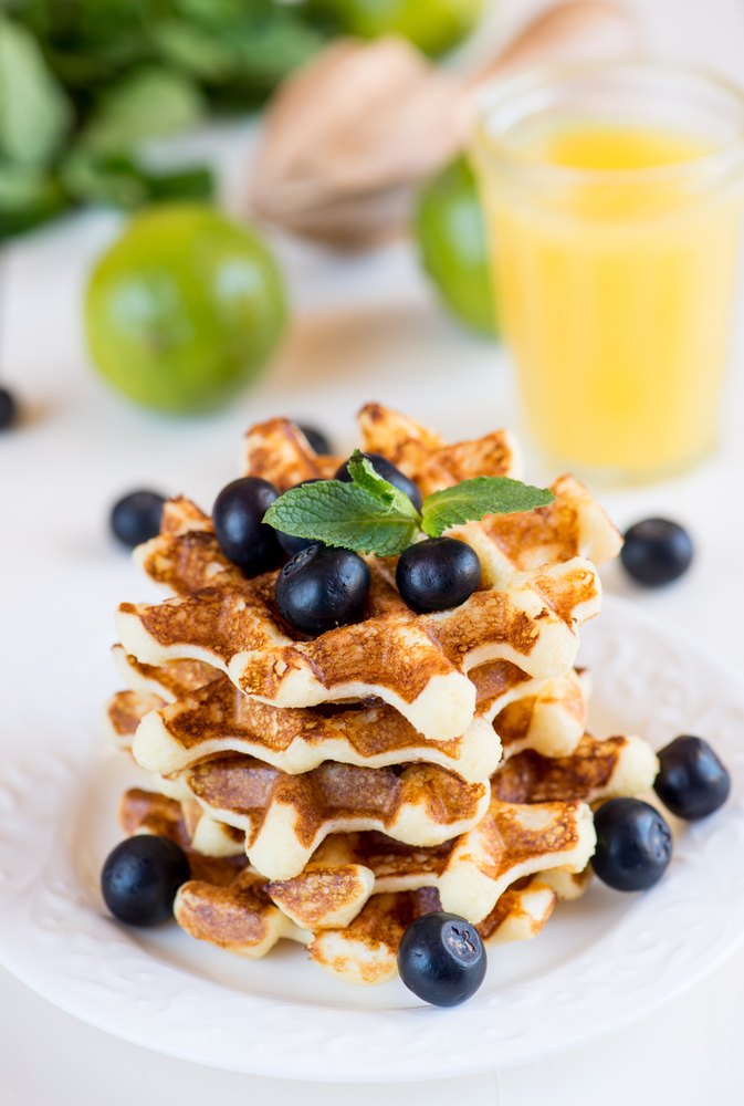 A stack of Belgian waffles with blueberries on top