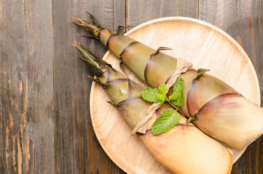 A light colored wooden plate with bamboo shots