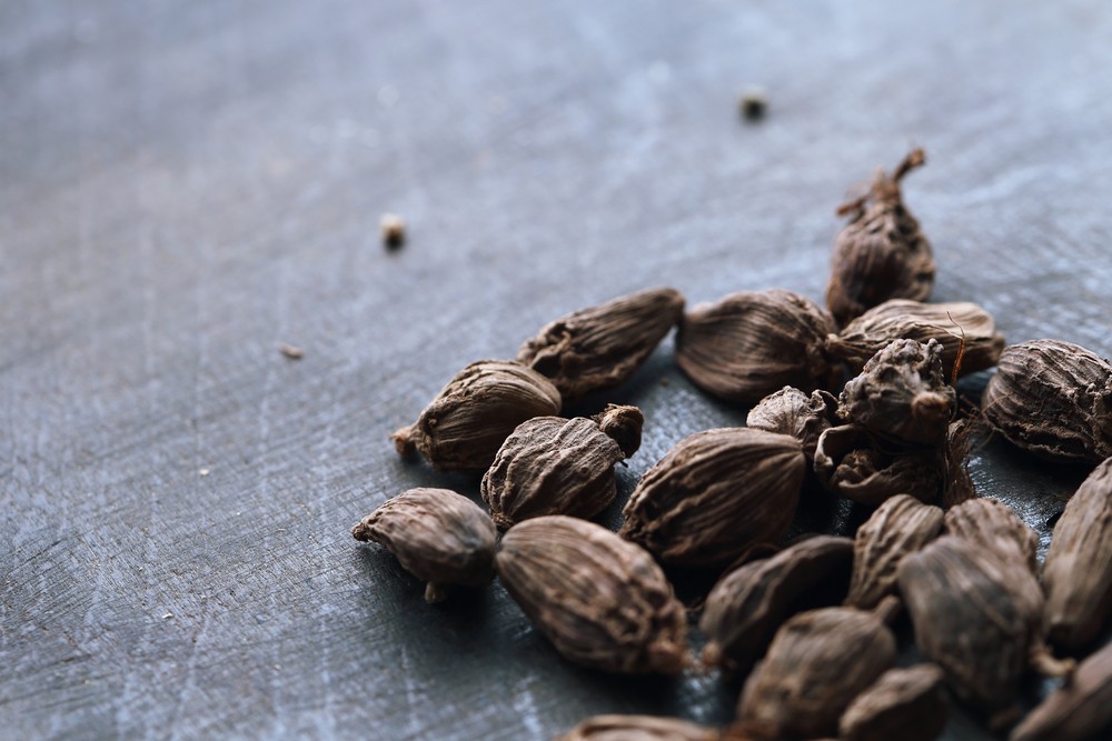 A small pile of black cardamom on a cloth or table