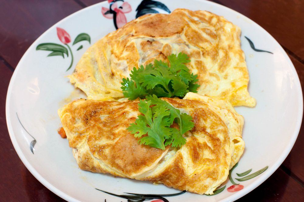 A large plate with two omelets and herbs