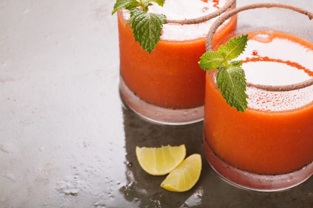 Two glasses of a bloody Mary cocktail with peppermint as a garnish