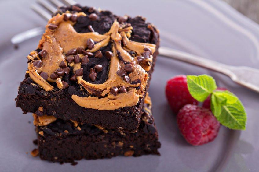 A stack of peanut butter and chocolate brownies, next to a few raspberries