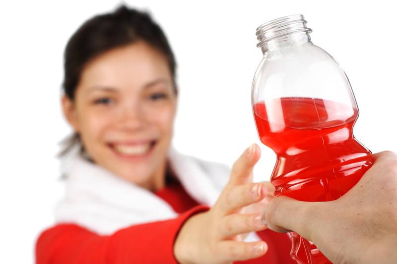 Young woman being given a sports drink