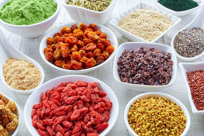 Selection of superfoods in white bowls