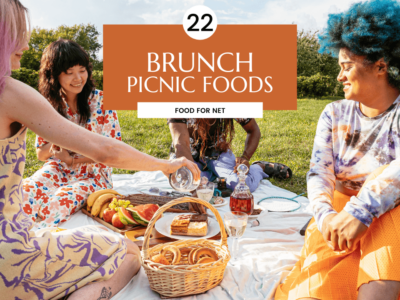 A group of people outside sitting on a blanket having a brunch picnic