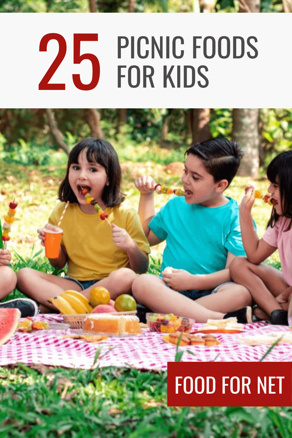 A group of kids sitting on a picnic mat outside eating fruit kebabs, highlighting some of the best picnic foods for kids