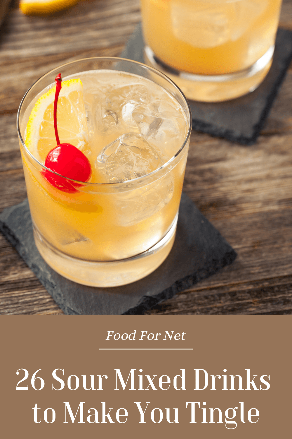 Two cocktail glasses containing a whiskey sour on a wooden table, highlighting sour mixed drinks