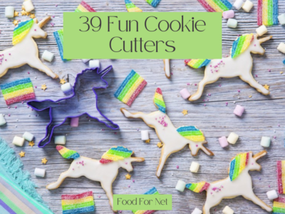 A light colored wooden table with cookie unicorns, a unicorn cookie cutter and rainbows, as an example of fun cookie cutters