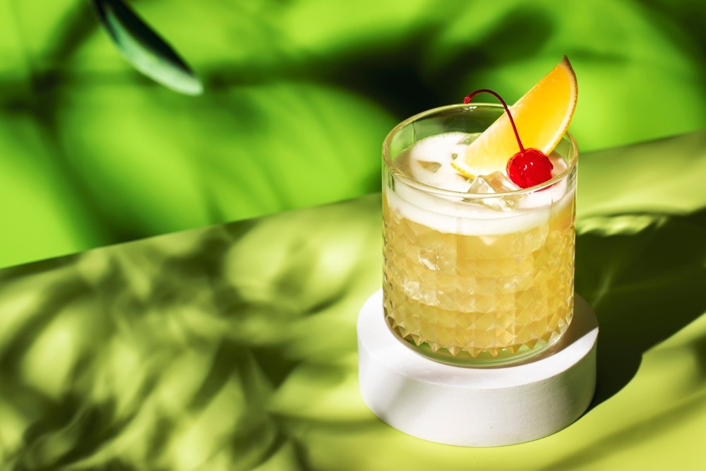 A Calabasas Cooler cocktail on a green table with a green background