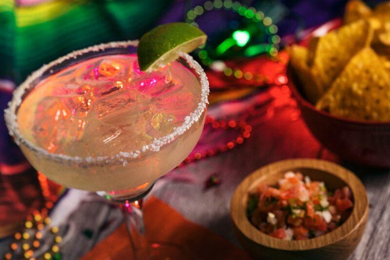 A freshly made Fireball margarita on a table with Mexican food and decorations