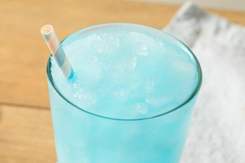 A close up image of a Jack frosty cocktail in a glass. The cocktail is a sky blue slushie