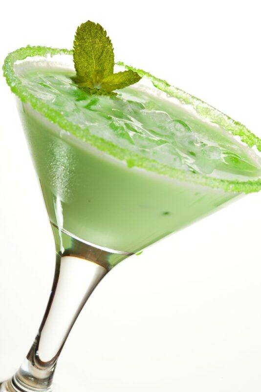 A martini glass containing a Midori pina colada cocktail