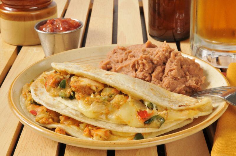 A Tex-Mex meal with refried beans on a wooden table