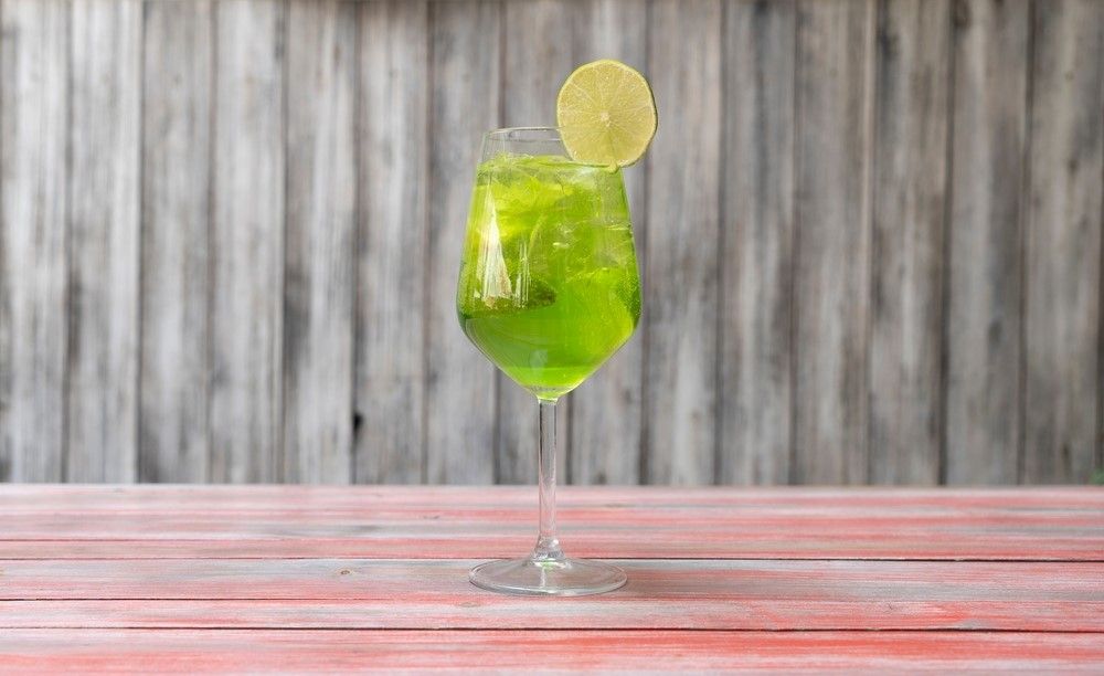 A single glass containing Tokyo iced tea garnished with a piece of lemon