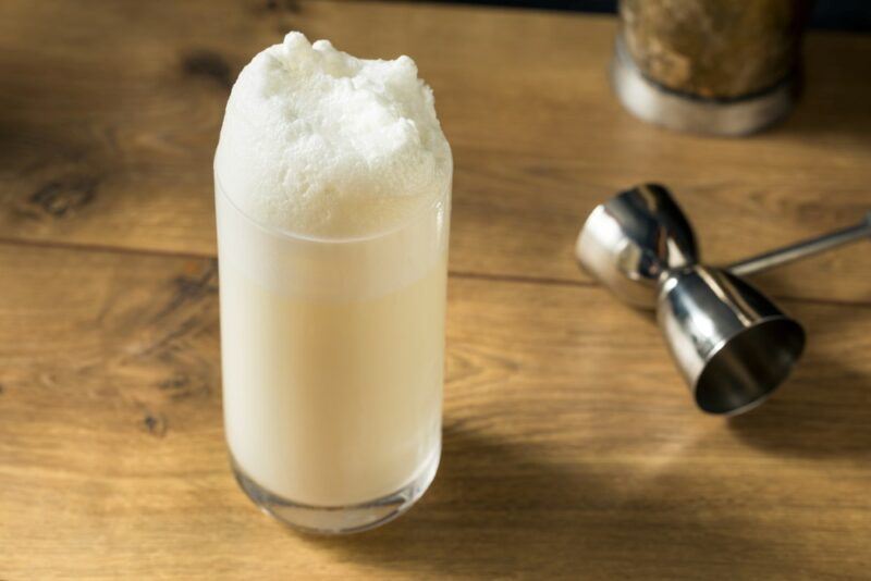 A wooden table with a traditional Ramos gin fizz that can be easily modified to include White Claw