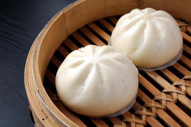 A bamboo steamer containing two Chinese dumplings