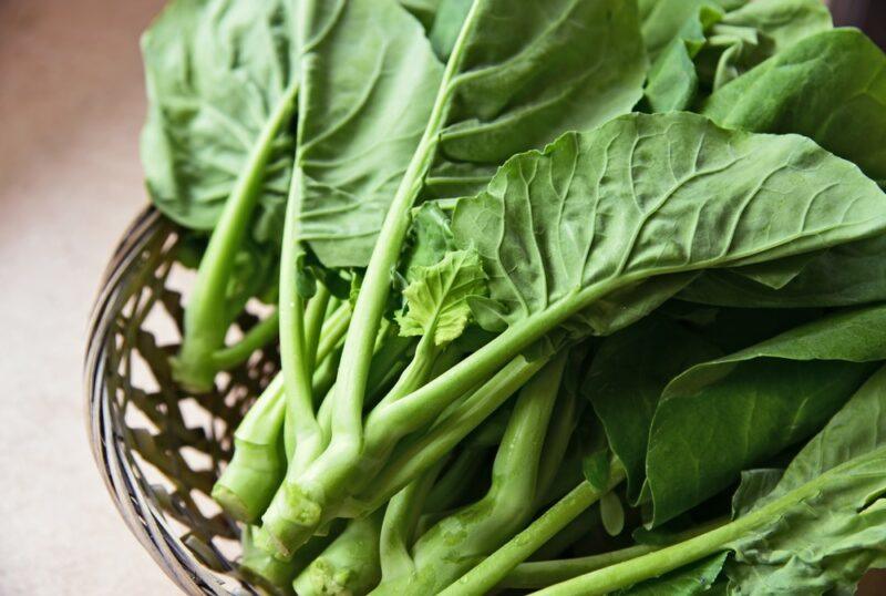 A basket containing kai lan greens, also known as Chinese broccoli