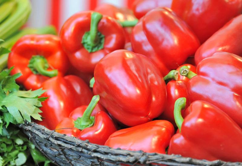 A dark basket piled high with bell peppers