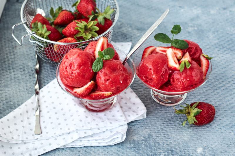 Two glasses of berry sorbet with strawberries