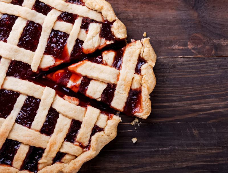 A berry pie with lattice as the top on a wooden table