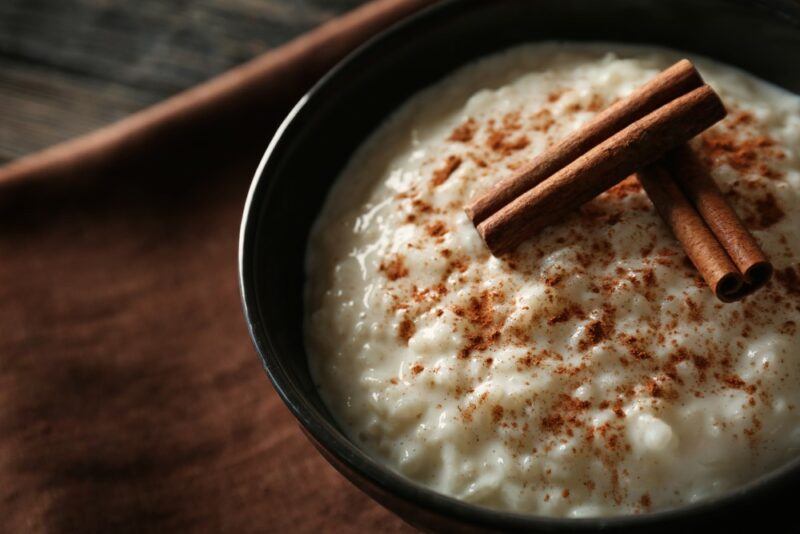 A black bowl filled with a cinnamon rice pudding called arroz con dulce