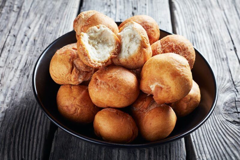 A black bowl with fried dumplings on a wooden table