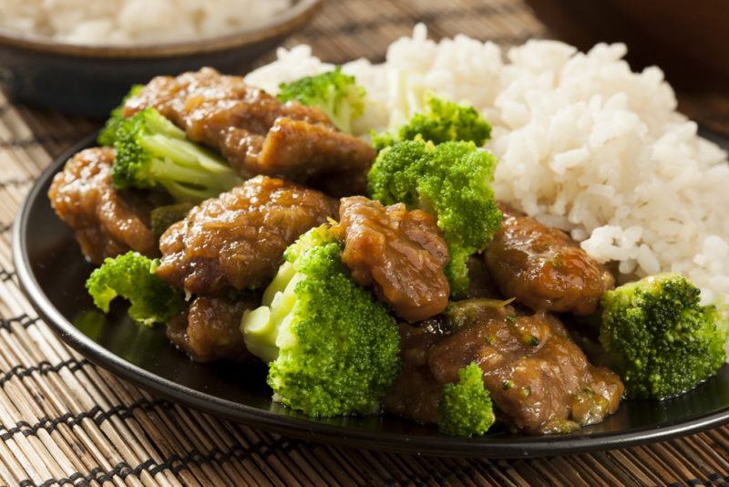 A black dish with beef, broccoli and white rice