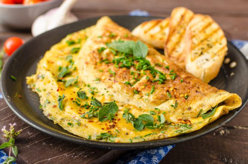 A black plate with a folded over omelet