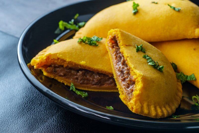 A black plate with various meat stuffed patties