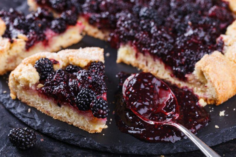 A cheesecake or pie that has many blackberries on the top