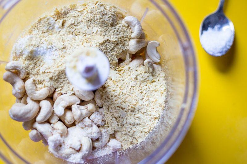 A blender bowl with cashews, which have been partly ground