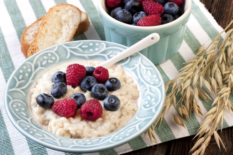 A light blue plate with instant oatmeal, raspberries and blueberries