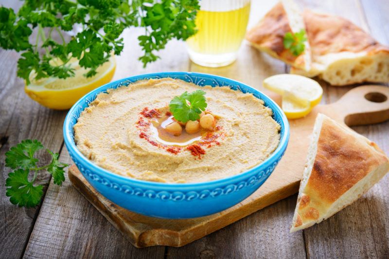 A light blue bowl filled with hummus