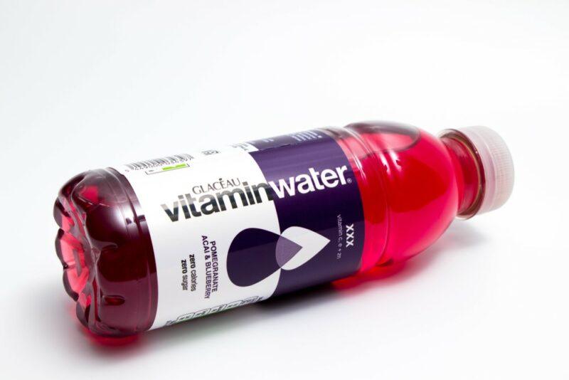 A single bottle of XXX vitaminwater lying sideways isolated on white