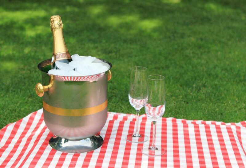 A bottle of bubbly in ice next to two glasses