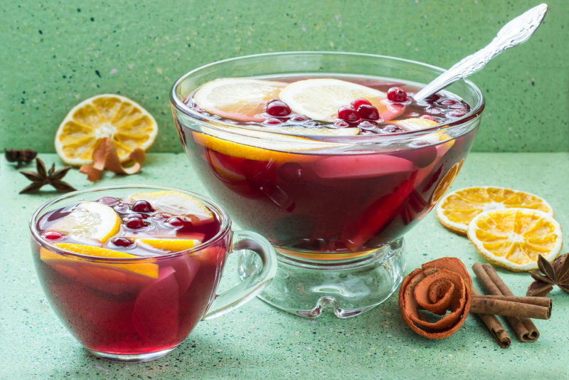 A large bowl of punch and a mug of punch