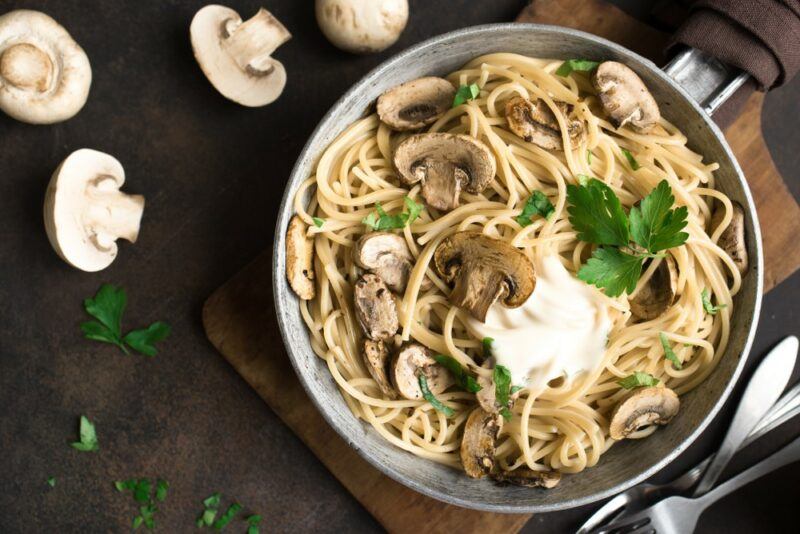 A stainless steel frypan with mushrooms