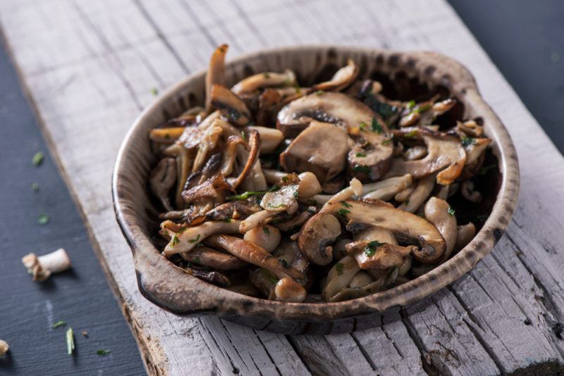 A brown bowl of cooked mushrooms