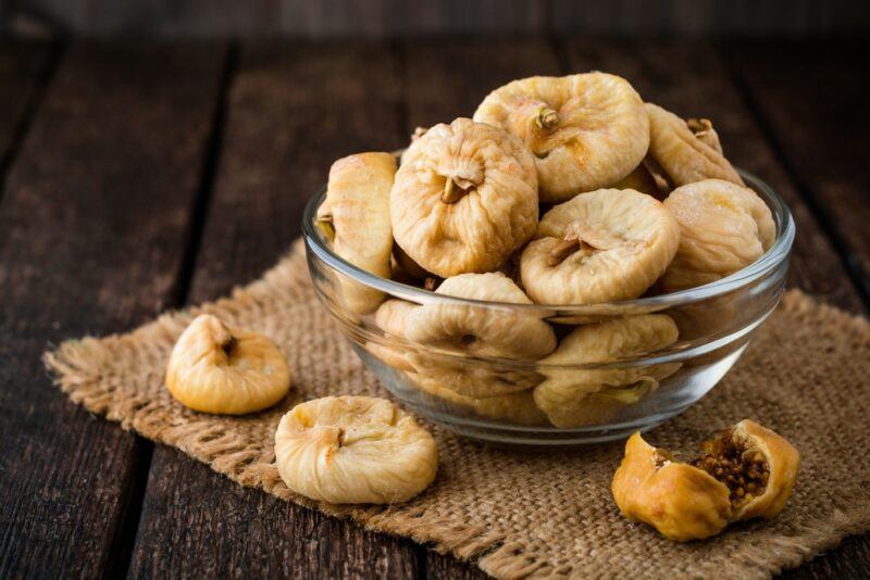 A glass bowl containing dried figs