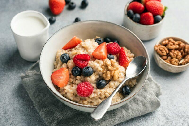 A large white bowl of oatmeal with fruit on top