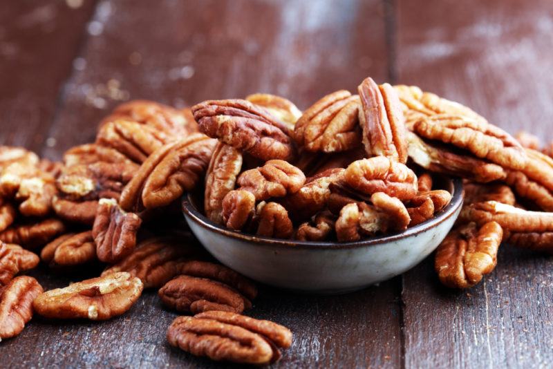 A bowl of pecans on a wooden table