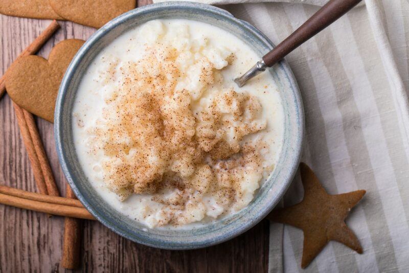 A grey bowl of porridge on a table with a spoon