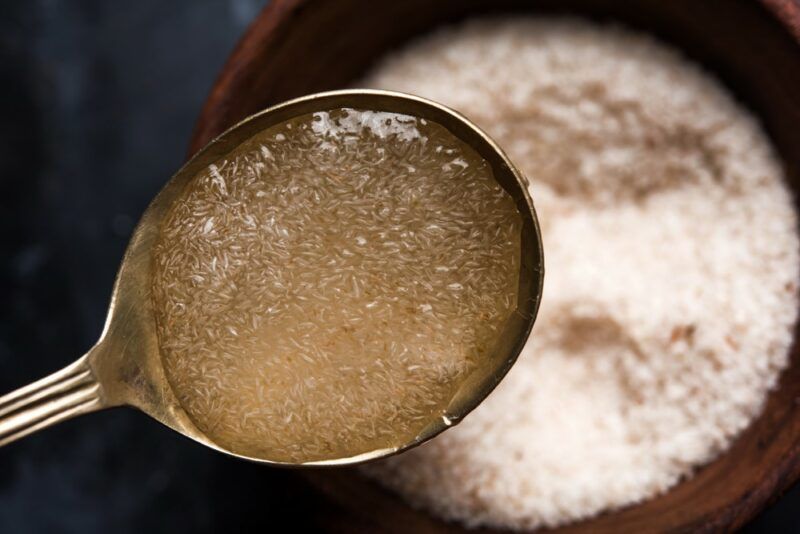 A wooden bowl of psyllium husk powder, with a metal spoon where the powder has been gelled