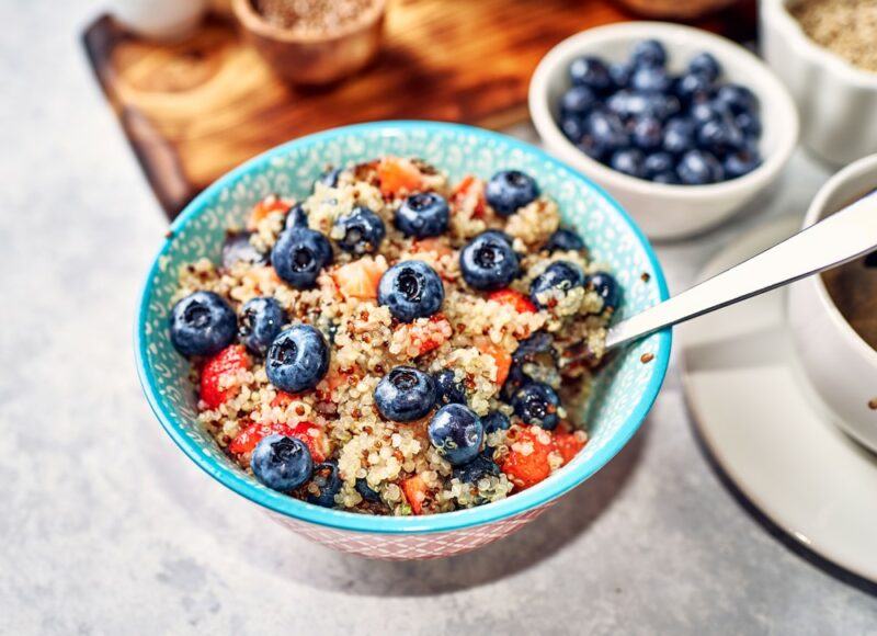 A blue bowl filled with a quinoa porridge breakfast