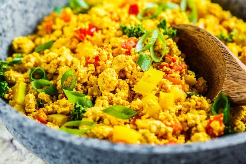 A large bowl containing scrambled tofu with vegetables