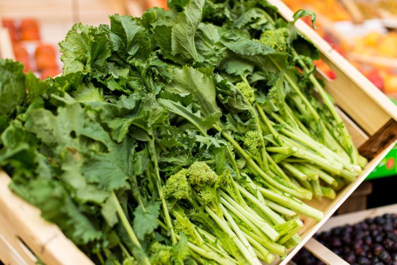 A box that contains turnip greens, all neatly aligned